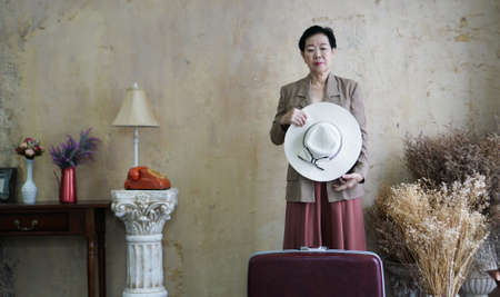 Asian senior woman vintage retro fashion with travel luggage luxury retriement lifeの写真素材