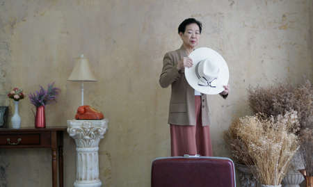 Asian senior woman vintage retro fashion with travel luggage luxury retriement lifeの写真素材