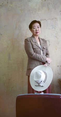 Asian senior woman vintage retro fashion with travel luggage luxury retriement lifeの写真素材