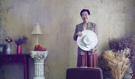 Asian senior woman vintage retro fashion with travel luggage luxury retriement lifeの写真素材