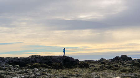Man sihouette on Icealnd rock formatoin beautiful sky
