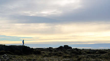 Man sihouette on Icealnd rock formatoin beautiful skyの写真素材