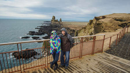 Asian senior couple photo with Iceland pennisula rock landmarkの写真素材