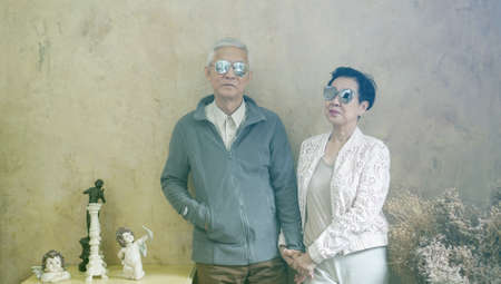 Happy Asian senior couple casual dress with sunglasses in vintage style houseの写真素材