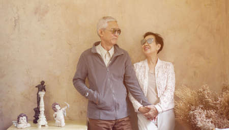 Happy Asian senior couple casual dress with sunglasses in vintage style houseの写真素材