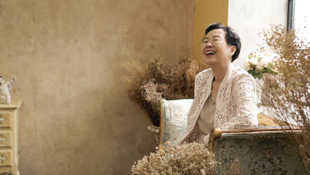 Asian senior woman sit in beautiful luxury interior room tuscan vintage style