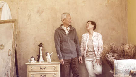 Happy Asian senior couple casual dress with sunglasses in vintage style houseの写真素材