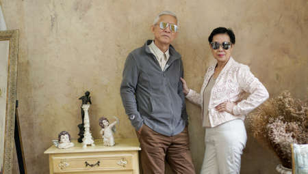 Happy Asian senior couple casual dress with sunglasses in vintage style houseの写真素材