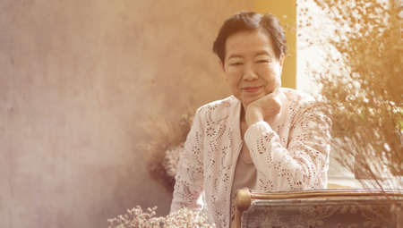 Asian senior woman sit in beautiful luxury interior room tuscan vintage styleの写真素材