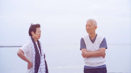 Asian elderly couple fight upset at ocean sea beachの写真素材