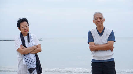 Asian elderly couple fight upset at ocean sea beachの写真素材