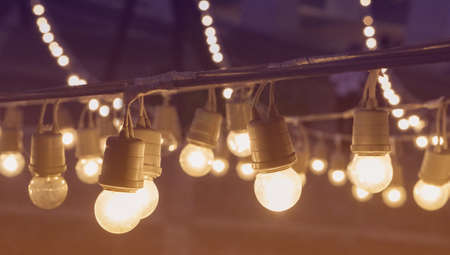Festival garland light bulbs hanging over outdoor  shopping area copy spaceの写真素材