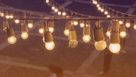 Festival garland light bulbs hanging over outdoor  shopping area copy spaceの写真素材