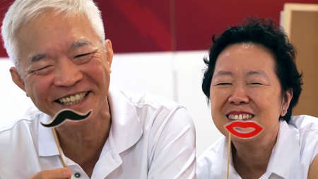 Happy playful Asian elderly senior couple togetherの写真素材