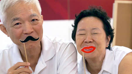 Happy playful Asian elderly senior couple togetherの写真素材