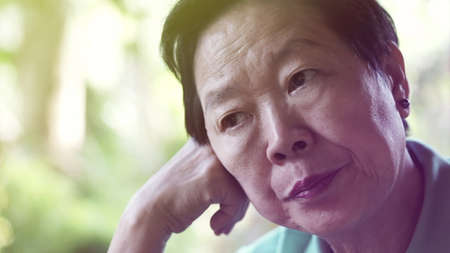 Asian senior elderly woman worry expression thinking about lifeの写真素材