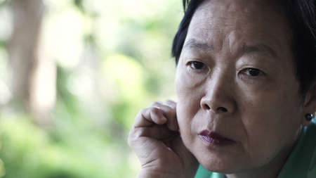 Asian senior elderly woman worry expression thinking about lifeの写真素材