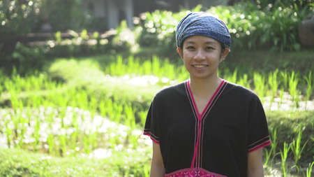 Asian ethnic woman with native dress smile at her mornign organic rice fieldの写真素材