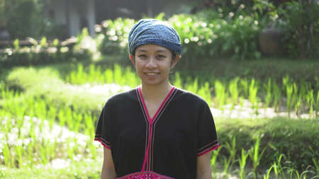 Asian ethnic woman with native dress smile at her mornign organic rice fieldの写真素材