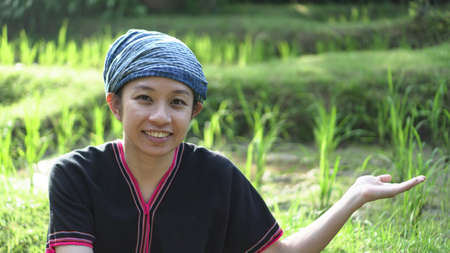 Asian ethnic woman with native dress smile at her mornign organic rice fieldの写真素材