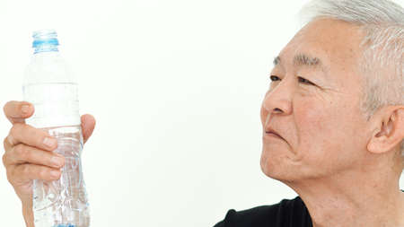Asian senior man hold water bottle drink for healthの写真素材
