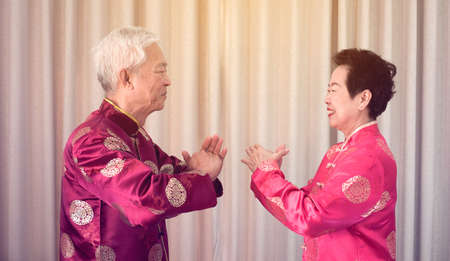 Asian senior couple celebrate Chinese new year in red costumeの写真素材