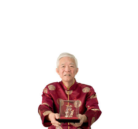 Asian senior man give gold pig sculpture for Chinese new yearの写真素材