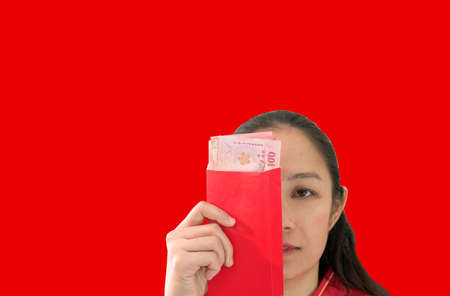 Unhappy Chiense woman and red envelop with money New Yearの写真素材