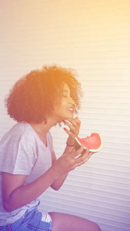 African girl eating summer watermelon happyの写真素材