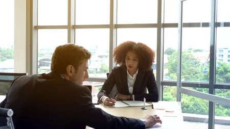 Serious colleague working together hispanic manager and African team mateの写真素材