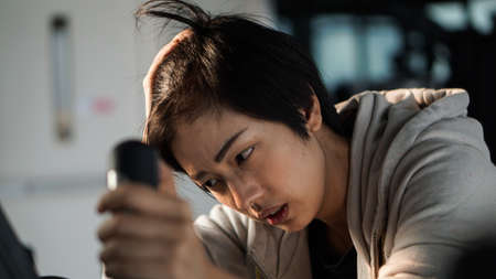 South East Asian woman exhausted from overtraining unhealthy excercise habitの写真素材