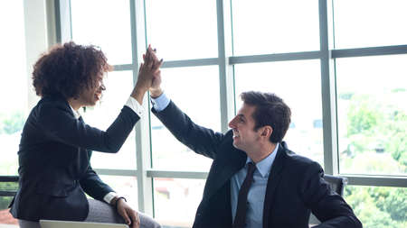 Hispanic and black interracial colleague high five congratulate workの写真素材