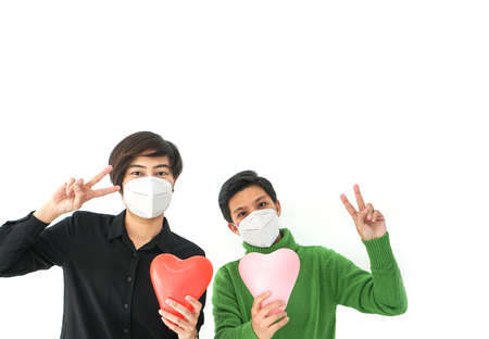 Two Asians friends wearing mask victory sign positive enourage with Covid-19 virus better situation