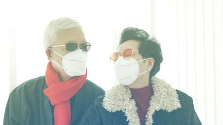 Asian fashion senior couple waring mask to prevent Covid-19 virus and pollution in Winter