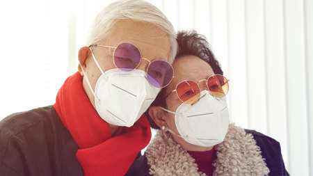 Asian fashion senior couple waring mask to prevent Covid-19 virus and pollution in Winterの写真素材
