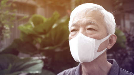 Asian Chinese senior man wearing mask protection from Coronavirus anxious scareの写真素材