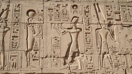 Karnak temple heiroglyphic pharaoh and god carving on sandstone wall