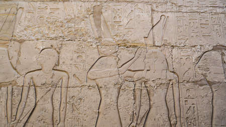 Luxor Egypt Karnak temple sandstone craved hieroglphic wall and column pharoah and anceint story