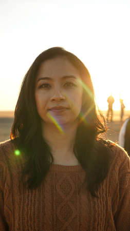 Asian woman with sunrise in desert backgorund beautiful make up wearing sweaterの写真素材