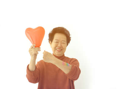 Asian elder mother support LGTBQ children smile with rainbow pride paint and balloon heart