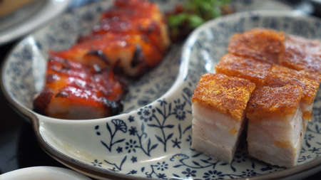 Chopsticks eating honey barbecue pork and crispy Hong Kong Cantonese traditional cuisineの写真素材
