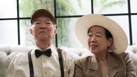 Vintage retro classic dress Asian senior elder couple taking photo at luxury home togetherの写真素材