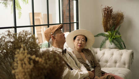 Vintage retro classic dress Asian senior elder couple taking photo at luxury home togetherの写真素材
