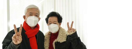 Asian senior elder couple send encourage for Covid-19 pandemic wearing mask protectionの写真素材
