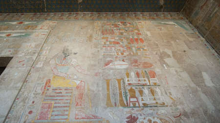 Hieroglyphics with remained colorful painting over craved stone wall  at Mortuary Temple of...
