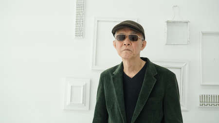 Handsome Asian senior model in fashion and sunglasses dress up white background