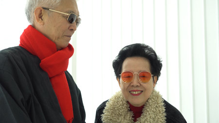 Asian senior elder couple winter cloth red scarft talking indoorの写真素材