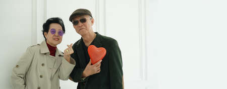 Asian senior couple winter dress up valentines love concept heart balloonの写真素材