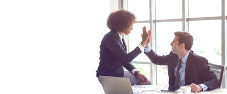 Hispanic and black interracial colleague high five congratulate workの写真素材