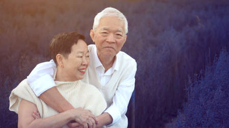 Asian senior couple hugging dating anniversary at purple flower fieldの写真素材